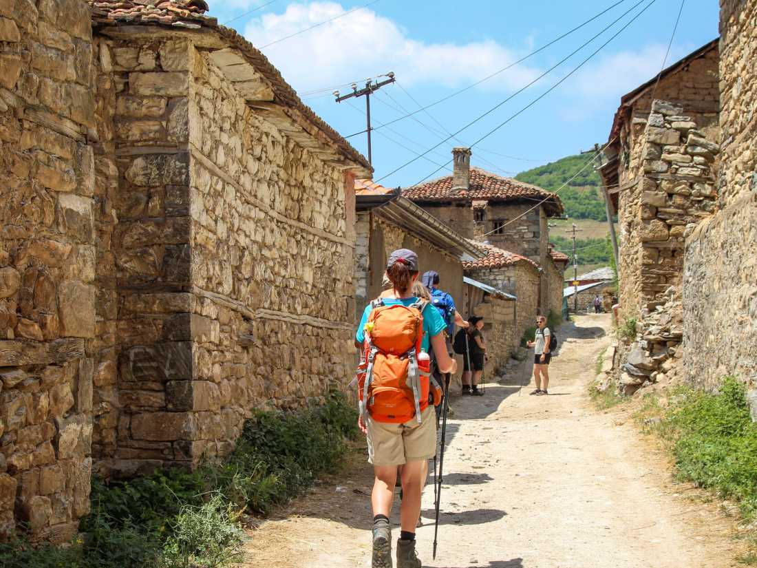 Hiking through a village on the Peaks of the Balkans Trail